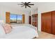 Bedroom boasts ceiling fan, wood floors, view and decorative shuttered window at 38199 N Tranquil Way, Carefree, AZ 85377