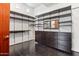Spacious walk-in closet with custom shelving and dark wood drawers for optimal storage at 38199 N Tranquil Way, Carefree, AZ 85377
