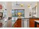 Modern kitchen with stainless steel appliances and breakfast bar, overlooking living area and desert landscape at 38199 N Tranquil Way, Carefree, AZ 85377