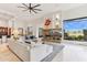 Bright living room featuring a stone fireplace, an open floor plan, and desert views at 38199 N Tranquil Way, Carefree, AZ 85377