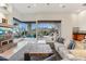 Bright living room with stone fireplace and expansive views of outdoor patio and desert landscape at 38199 N Tranquil Way, Carefree, AZ 85377