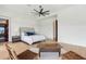 Relaxing main bedroom featuring hardwood floors, white walls, a cozy bed, and easy access to a restroom at 38199 N Tranquil Way, Carefree, AZ 85377