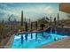 Beautiful backyard pool featuring desert landscaping, mountain views, and a waterfall feature at 38199 N Tranquil Way, Carefree, AZ 85377