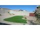 Manicured backyard featuring artificial grass, rock landscaping, a brick privacy wall and a hot tub at 4076 E Silverbell Rd, San Tan Valley, AZ 85143