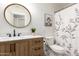 Charming bathroom with a wood vanity, white marble counter, round mirror, and decorative shower curtain at 4076 E Silverbell Rd, San Tan Valley, AZ 85143