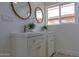 Close-up of the bathroom vanity featuring dual sinks, framed mirrors, modern fixtures, and stylish white cabinetry at 4109 N 30Th Ave, Phoenix, AZ 85017