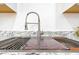A close up on a stainless steel kitchen sink with a cutting board insert with matching granite counters at 4109 N 30Th Ave, Phoenix, AZ 85017