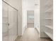 Well-lit bathroom boasts a glass-enclosed shower, tub, double vanity, and ample shelving for storage at 4364 W Hannah St, San Tan Valley, AZ 85144