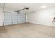Spacious two-car garage featuring a roll-up door and bright lighting at 4364 W Hannah St, San Tan Valley, AZ 85144