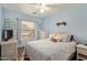Cozy bedroom with blue walls, white wicker furniture, and a ceiling fan for comfortable living at 45068 W Alamendras St, Maricopa, AZ 85139