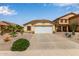 A tan home featuring a two car garage door and desert landscaping on a sunny day at 45068 W Alamendras St, Maricopa, AZ 85139