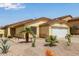 Exterior view of a one-story tan home featuring desert landscaping and a tile roof at 45068 W Alamendras St, Maricopa, AZ 85139