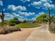 Charming backyard with a paved pathway, desert landscaping, and a glimpse of the house nestled amongst the trees at 4867 E Windstone Trl, Cave Creek, AZ 85331