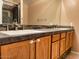 Bathroom double vanity sink with neutral stone counter and dark stone accent wall at 4867 E Windstone Trl, Cave Creek, AZ 85331