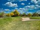 Picturesque golf course view featuring lush green grass, mature trees, and a bright blue sky with fluffy white clouds at 4867 E Windstone Trl, Cave Creek, AZ 85331