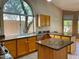 Well-lit kitchen featuring granite countertops, oak cabinetry, stainless steel appliances, and lots of counter space at 4867 E Windstone Trl, Cave Creek, AZ 85331