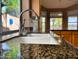 Close-up of a kitchen sink with granite countertops and a window with greenery outside at 4867 E Windstone Trl, Cave Creek, AZ 85331