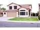 Inviting two-story residence showcasing a two-car garage, tiled roof, and lush green lawn at 488 W Harvard Ave, Gilbert, AZ 85233