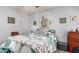 Cozy bedroom featuring a bed, mirrored wall decor, wood flooring, and soft natural lighting at 5221 W Garden Dr, Glendale, AZ 85304