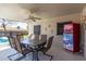 Covered patio with dining table, ceiling fan, decorative painted refrigerator and view of swimming pool at 5221 W Garden Dr, Glendale, AZ 85304