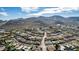 Wide aerial shot showcasing a neighborhood nestled beneath the majestic backdrop of a mountain range at 544 W Thunderbird Rd, Phoenix, AZ 85023