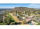 Aerial view shows residential homes near a golf course under clear blue skies and a scenic mountain backdrop at 544 W Thunderbird Rd, Phoenix, AZ 85023