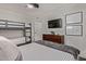 Cozy bedroom featuring a bunk bed, a large bed, and a modern television mounted on the wall at 544 W Thunderbird Rd, Phoenix, AZ 85023