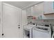 Laundry room with white washer and dryer, shelving, and storage cabinets at 544 W Thunderbird Rd, Phoenix, AZ 85023