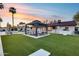 This backyard paradise offers a covered patio, beautiful pool, plenty of space for entertaining, and lush green landscaping at 5975 E Larkspur Dr, Scottsdale, AZ 85254