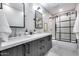Stylish bathroom featuring double sinks, quartz countertops, and a glass shower at 5975 E Larkspur Dr, Scottsdale, AZ 85254