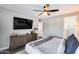 Modern bedroom featuring a large flat-screen TV, ceiling fan, and stylish decor at 5975 E Larkspur Dr, Scottsdale, AZ 85254