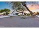 Single story home with modern exterior, xeriscaping, and long driveway to a gray two-car garage at 5975 E Larkspur Dr, Scottsdale, AZ 85254