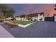 Charming single-story home with a manicured front lawn, vibrant flowerbeds, and a spacious driveway at 5975 E Larkspur Dr, Scottsdale, AZ 85254