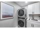 Cozy laundry room featuring stacked washer and dryer and bright white cabinetry and countertop at 5975 E Larkspur Dr, Scottsdale, AZ 85254