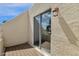 Balcony with wooden deck, stucco wall and railing, and sliding glass doors to the inside at 6009 N 79Th St, Scottsdale, AZ 85250
