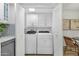 Laundry room with modern, full-size washer and dryer inside of folding closet doors at 6009 N 79Th St, Scottsdale, AZ 85250