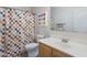 Bright bathroom featuring a colorful shower curtain, a vanity and a modern mirror at 6228 S Nash Way, Chandler, AZ 85249