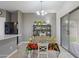 Bright dining room with modern chandelier, adjacent to the kitchen and access to patio at 6228 S Nash Way, Chandler, AZ 85249