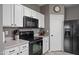 Functional kitchen with black appliances, white cabinets, and a gray backsplash at 6228 S Nash Way, Chandler, AZ 85249