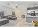 Bright living area with gray walls, tile floor, a large gray sofa, and view to the kitchen at 6228 S Nash Way, Chandler, AZ 85249