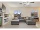 Cozy living room features neutral walls, a large gray couch, and an entertainment center at 6228 S Nash Way, Chandler, AZ 85249