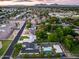 Expansive aerial view of a home with a pool, sports court, and lush landscaping under a vibrant sunset sky at 6301 N 16Th Dr, Phoenix, AZ 85015