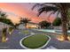 Stunning backyard featuring a pool, putting green, jacuzzi, and desert landscaping at dusk at 6301 N 16Th Dr, Phoenix, AZ 85015