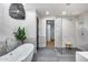 Modern bathroom featuring a soaking tub, glass enclosed shower with decorative tile, and contemporary lighting at 6301 N 16Th Dr, Phoenix, AZ 85015