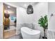 Elegant bathroom featuring a soaking tub, pendant lighting, and marble accents, with a view into the main bedroom at 6301 N 16Th Dr, Phoenix, AZ 85015