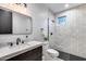 Bathroom featuring stone tiled walls, black finishes, and white marble counters at 6301 N 16Th Dr, Phoenix, AZ 85015