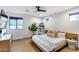 Bright bedroom with light wood floors, large windows, and a modern bed frame complemented by neutral decor at 6301 N 16Th Dr, Phoenix, AZ 85015