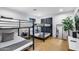 Bedroom featuring a bunk bed and twin bed, complemented by wood floors and a minimalist aesthetic at 6301 N 16Th Dr, Phoenix, AZ 85015