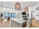 Open floor plan with kitchen island and view to living area with floor to ceiling windows at 6301 N 16Th Dr, Phoenix, AZ 85015