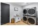 Modern laundry room with stacked washer and dryer, a utility sink, and contemporary finishes for convenience at 6301 N 16Th Dr, Phoenix, AZ 85015